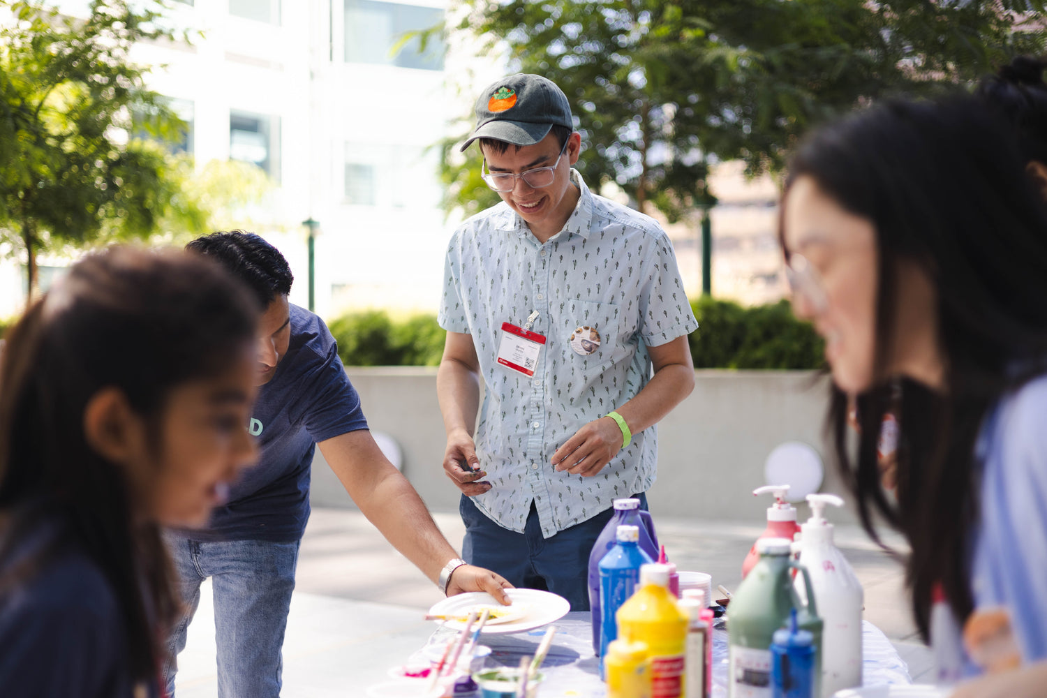 James Mertke is centered in the shot looking down as he help distribute plates of different colors of paint to event attendees.