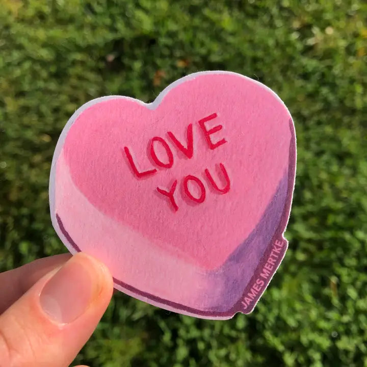 This sticker features a pink conversation heart candy with "LOVE YOU" written in red.