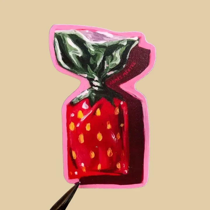 This sticker depicts a strawberry bonbon candy with a red and green wrapper and pink outline.