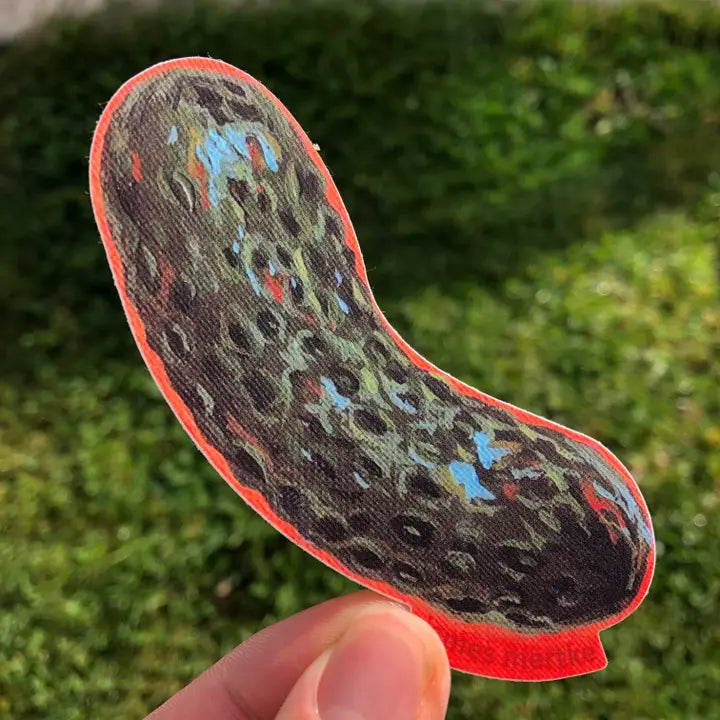 This sticker depicts a painting of a whole pickle with an orange outline.