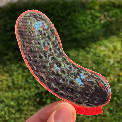 This sticker depicts a painting of a whole pickle with an orange outline.