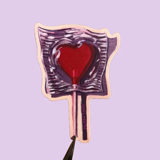 This sticker depicts a painting of a candy heart lollipop. The cany is red and casts a dramatic purple shadow.