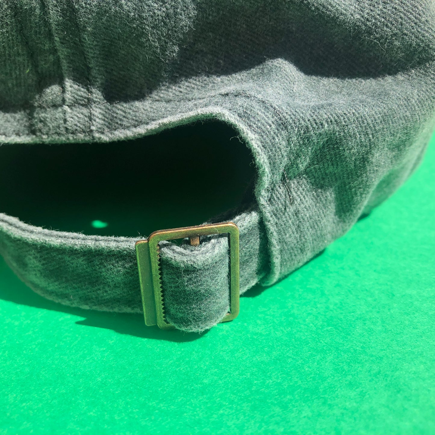 A close up shot of the back of the hat showing the metal buckle that makes the size of the hat adjustable.