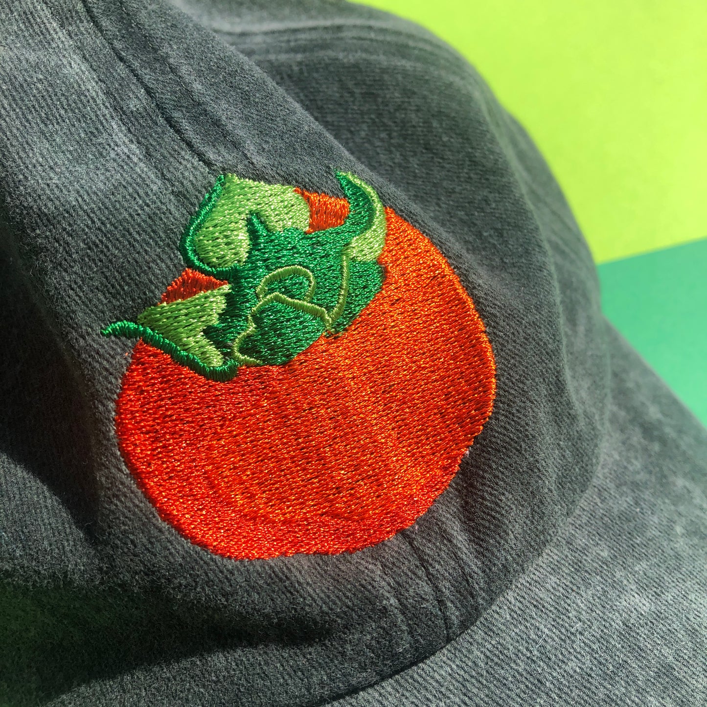 A close up of the embroidered persimmon design.