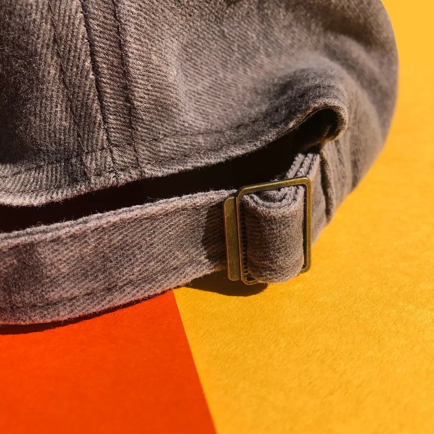 A close up shot of the back of the hat showing the metal buckle that makes the size of the hat adjustable.