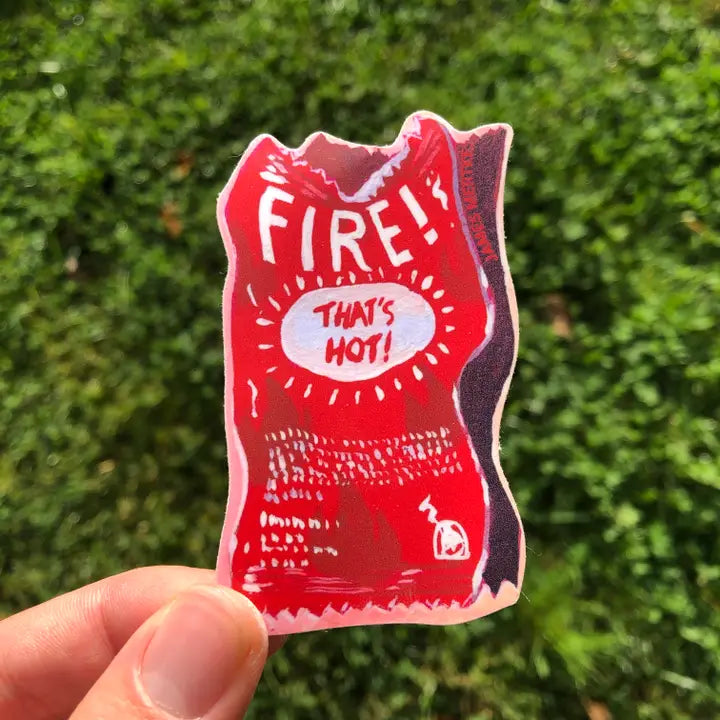 This sticker depicts a painting of a red hot sauce packet. "FIRE" is written at the top and "That's Hot" is written as a joke in the middle.
