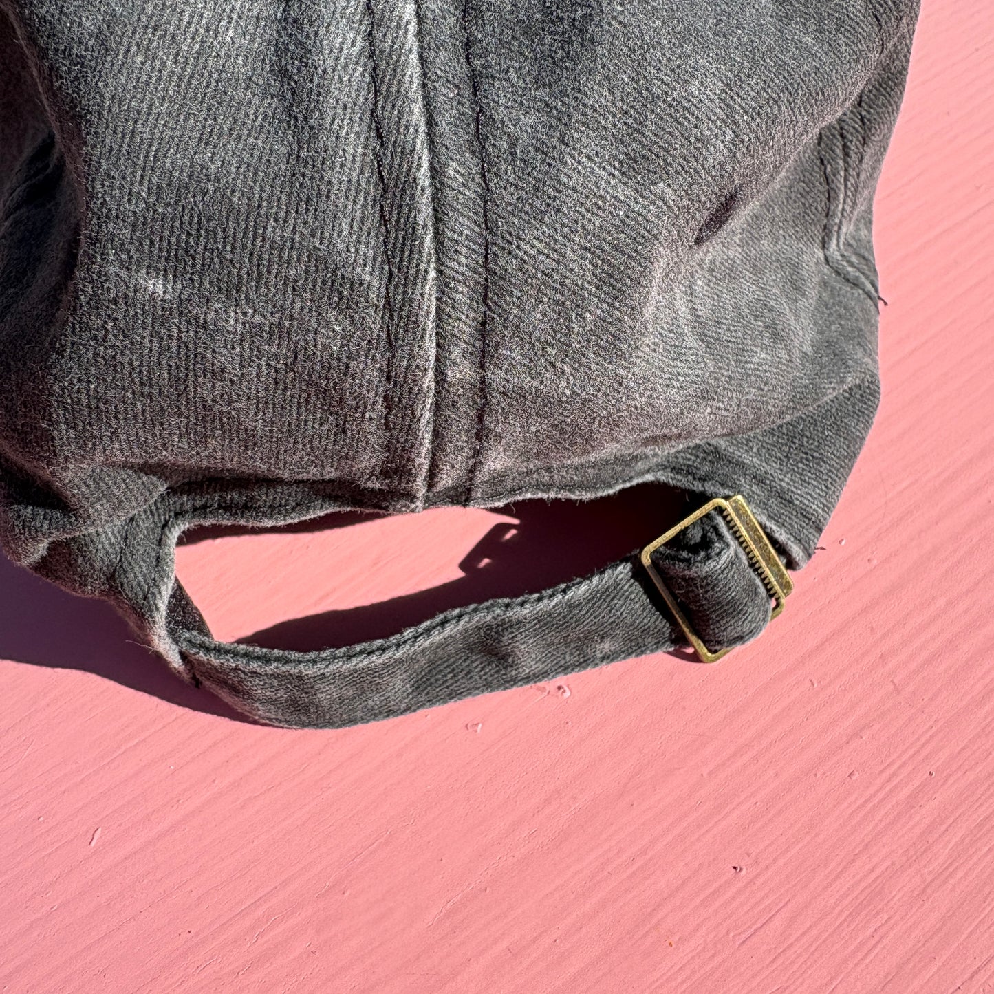 Close up of the adjustable size buckle on the back of the hat.