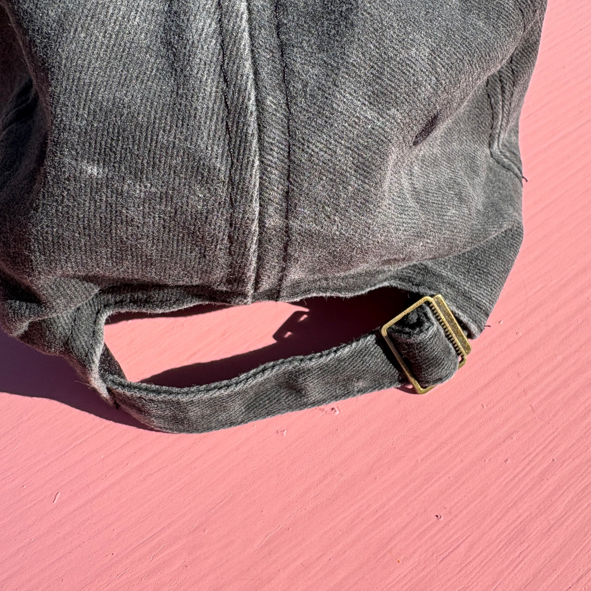 Close up of the adjustable size buckle on the back of the hat.