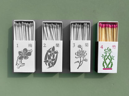 The set of four matchboxes are laid out next to each other. Only the bamboo design is in color while the rest have been turned black and white to emphasize which design is included in this listing.