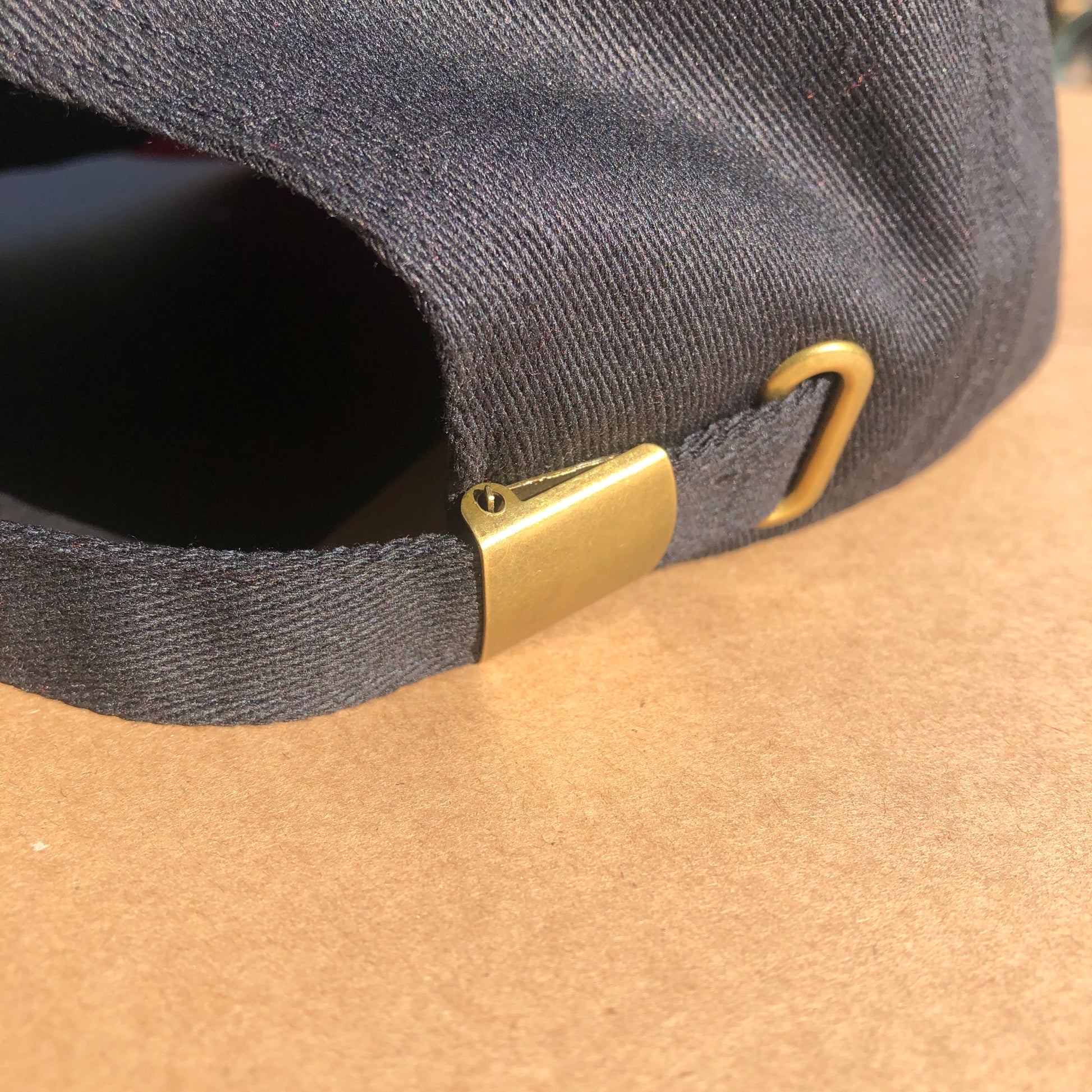 A close up shot of the back of the hat showing the metal buckle that makes the size of the hat adjustable.