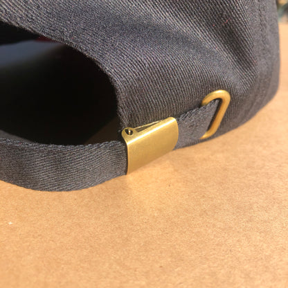 A close up shot of the back of the hat showing the metal buckle that makes the size of the hat adjustable.