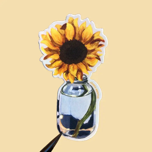 This sticker depicts a painting of a sunflower in a simple blue glass jar.