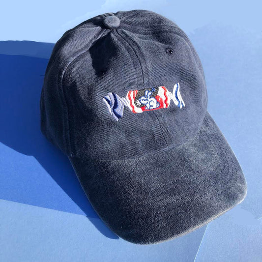 A dark blue hat is embroidered with a white rabbit candy design on the front.